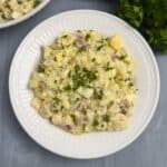 An overhead shot of Potato and Egg Salad in a white bowl.